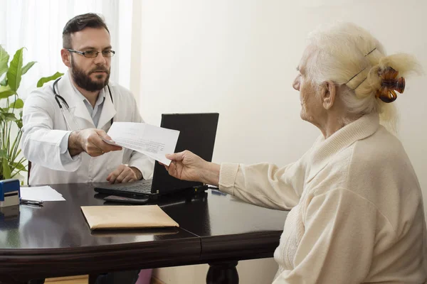 Un médico muestra un dedo escrito en la historia clínica del paciente . — Foto de Stock