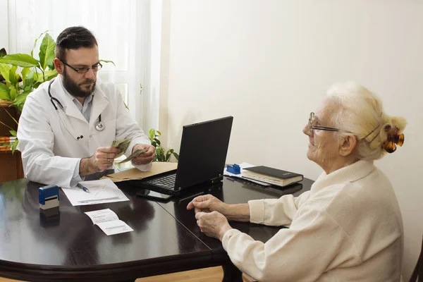Лікар показує пальцем, що пише в історії хвороби пацієнта . — стокове фото