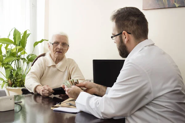 El médico recibe dinero para una visita al consultorio del médico. . — Foto de Stock