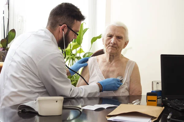 Examen médico con estetoscopio. Médico geriatra examinando pulmones . — Foto de Stock