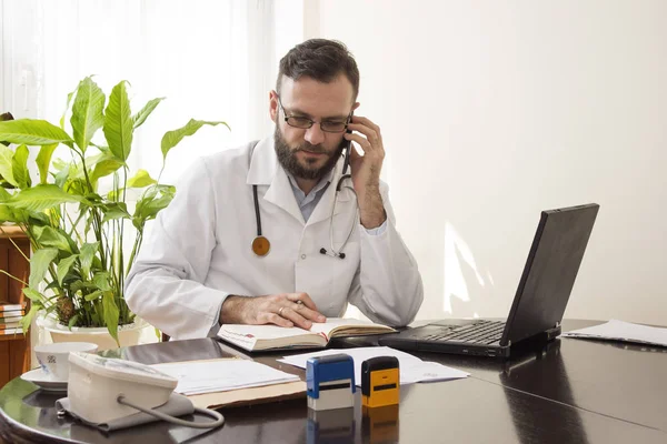 Doktor doktor ofisinde telefon ve takvim üzerinde mevcut tarihler için denetimler söz. 
