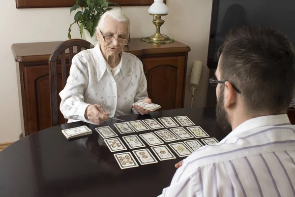 A avó põe o tarot neto. Fada idade coloca cartas de tarô — Fotografia de Stock