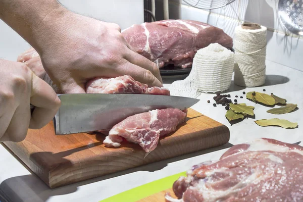 Разрезание сырого мяса кухонным ножом . — стоковое фото