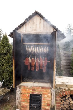 Raw meat in a smokehouse.  clipart