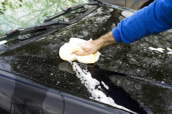 Männerhand wäscht die Schwammmaske des Autos mit viel Schaum. — Stockfoto