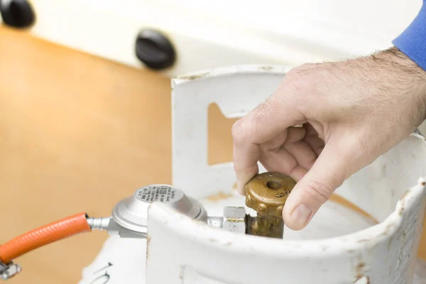 Elini gaz şişesi kapak unscrews.