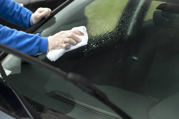 男の手が布で車のガラスを拭く. — ストック写真