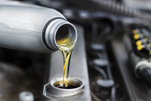 Arabanın motoru döktü motor yağı. Tamirci arabaya yağ değişimi yapan 