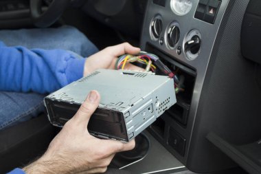 Tamirci bir araç radyosu bir araba radyo cebine koyar. Radyo bağlanma