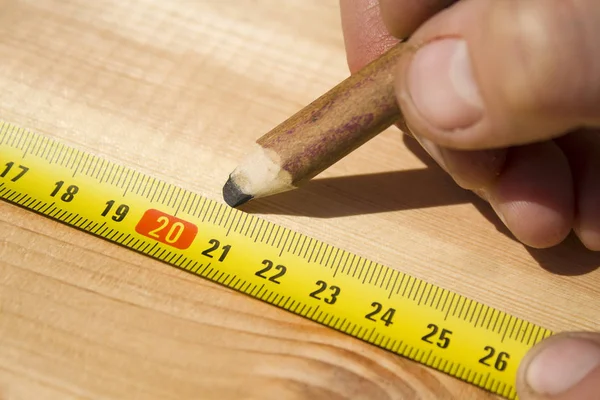 Marking distances. The carpenter\'s hands measure distance measure.
