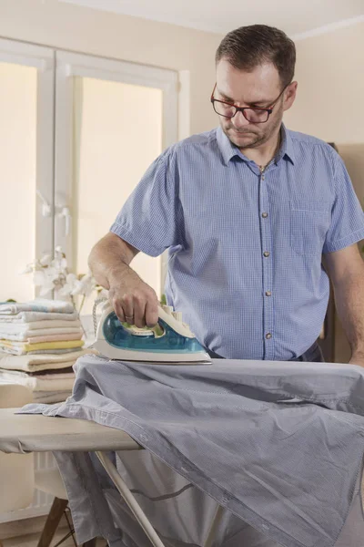 Ein Mann Wohnzimmer Bügelt Die Ärmel Eines Hemdes Auf Einem — Stockfoto