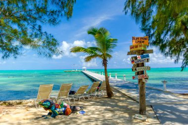 Rum Point, Grand Cayman, Cayman Islands July 2017, signpost by a jetty and the Caribbean Sea  clipart