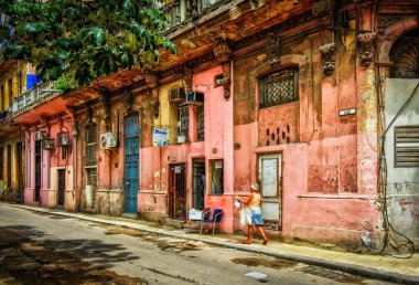Havana, Küba, Temmuz 2019, şehrin en eski bölgesinde renkli Calle Luz 'da yürüyen kadın.