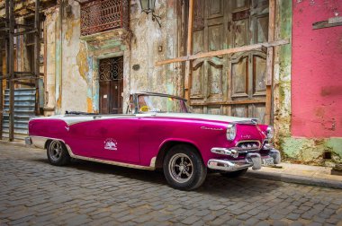 Havana, Küba, Temmuz 2019, Mor 50 'li yılların kiralık Dodge arabası şehrin en eski bölgesinde caddeye park edilmiş.