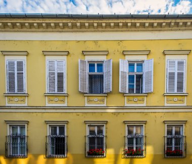 Macaristan, Budapeşte, Ağustos 2019, Buda Kalesi Bölgesi 'nde sarı bir binanın ön cephesini kapatın.