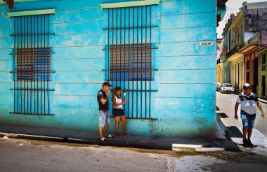 Havana, Küba, Temmuz 2019 Calle Aguiar 'da turkuaz bir duvarın yanında şehrin en eski yerinde dondurma yiyen bir çift.