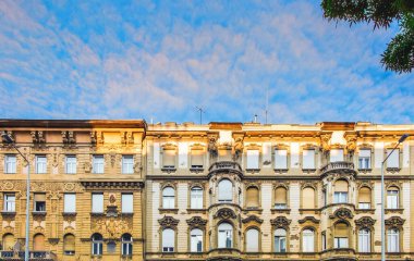 Budapeşte, Macaristan, Ağustos 2019, günbatımında mimari heykeli olan iki binanın üst kısımlarını görmek