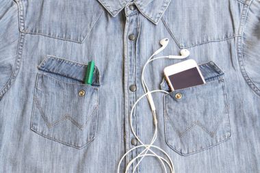 dokulu arka plan kot gömlek denim kumaş ve cebinde kulaklık ile hareket eden