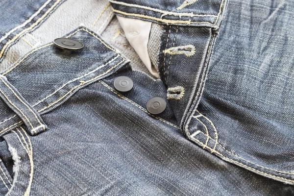 Bakgrunden texturerat knappar jeans byxor denim tyg — Stockfoto
