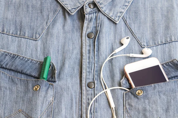dokulu arka plan kot gömlek denim kumaş ve cebinde kulaklık ile hareket eden