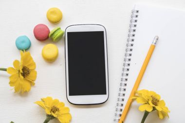 Mobil ve Sarı çiçekli masa beyaz renkli tatlı acıbadem kurabiyesi