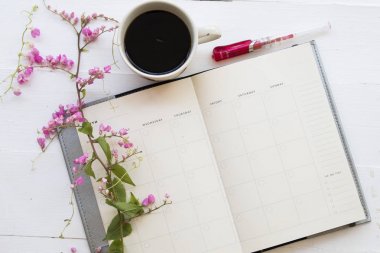 defter planlayıcısı yıllık ve sıcak kahve tablo beyaz üzerine pembe çiçekli