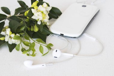 cep telefonu beyaz arka plan üzerinde beyaz çiçekli