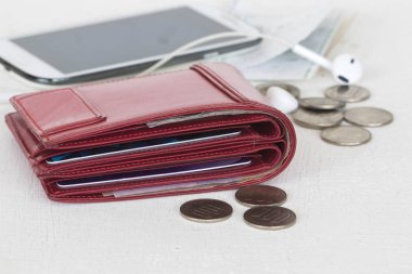 kırmızı çanta ve sikkeler cep telefonu, kredi kartı ile para masrafına masada beyaz fişleri.