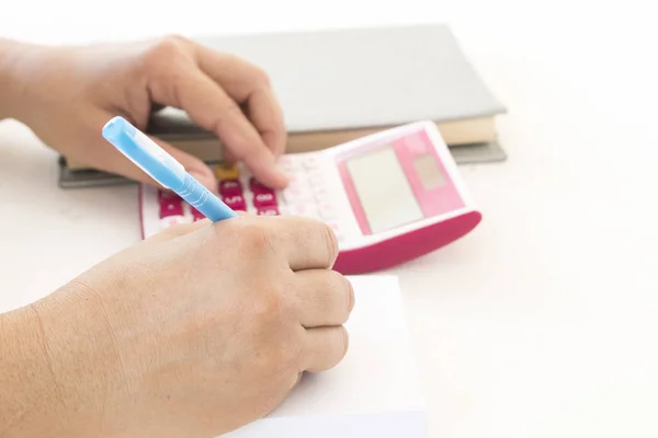 hand of woman working check account and writing post it note at office desk