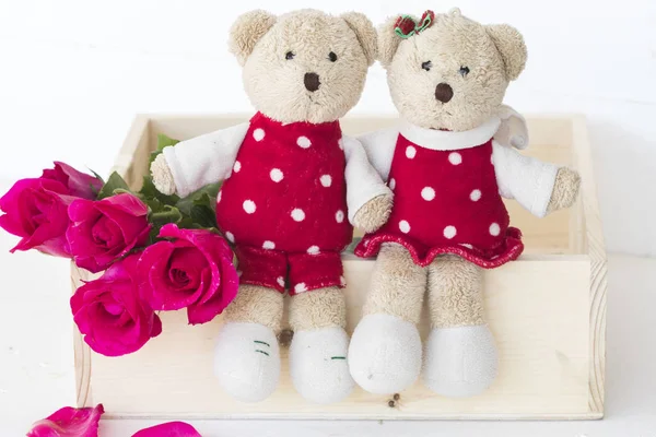couple teddy bear with pink rose on background white wooden