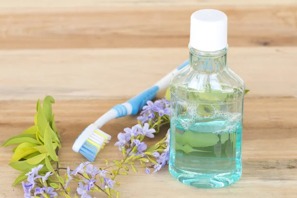 ahşap arka plan üzerinde sağlıklı bakım ağız boşluğu için gargara diş fırçası