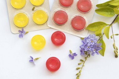 Boğaz pastil hapları üzerinde arka plan beyaz bitkisel öksürük