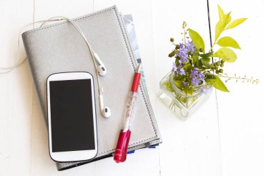 defter planlayıcısı yıllık ve şişe üzerinde tablo beyaz mor çiçek ile cep telefonu