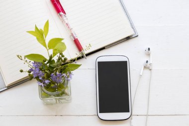 defter planlayıcısı yıllık ve şişe üzerinde tablo beyaz mor çiçek ile cep telefonu