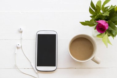 sıcak kahve fincanı ve çiçek beyaz tablo ile cep telefonu kulaklık 