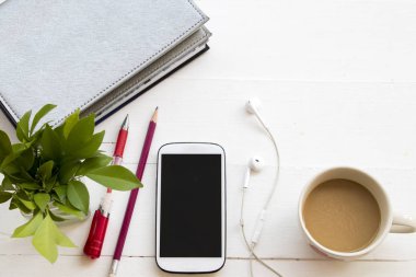 defter planlayıcısı cep telefonu iş için Ofis Masası beyaz masada sıcak kahve fincanı ile çalışmak