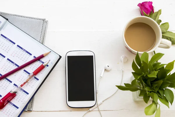 defter planlayıcısı cep telefonu iş için Ofis Masası beyaz masada sıcak kahve fincanı ile çalışmak