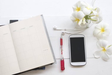 defter planlayıcısı ile iş ve Ofis Masası beyaz arka plan üzerinde beyaz çiçek frangipani için telefon kulaklık