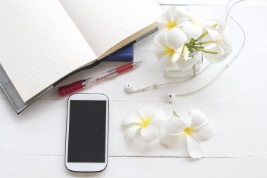 defter planlayıcısı ile iş ve Ofis Masası beyaz arka plan üzerinde beyaz çiçek frangipani için telefon kulaklık