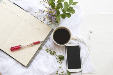 defter planlayıcısı popüler içecekler sıcak taze kavrulmuş kahve ve beyaz arka plan üzerinde cep telefonu kulaklık