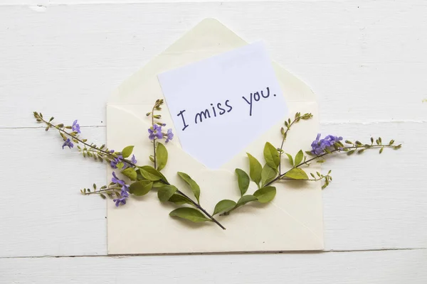 i miss you message card in envelope with purple flower on background white