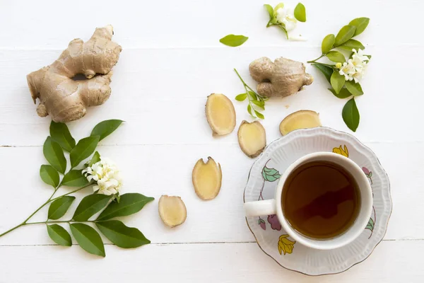 热姜汁草本健康饮料从自然与白色的花在白色木制 — 图库照片