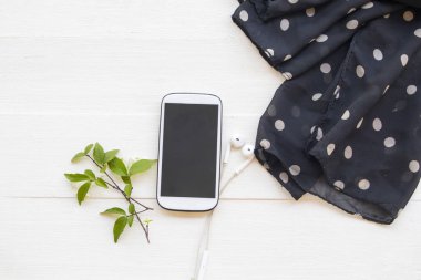 Siyah fularlı cep telefonu yaşam tarzı aksesuarları rahatlama düzenleme düz arka plan beyaz ahşap üzerine yatar