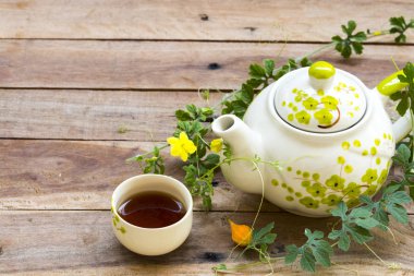 Bitkisel içecekler sıcak çay, çaydanlık ve çiçek sağlık hizmetleri için yaşam tarzı düzenleme düz arka plandaki ahşap üzerine uzanan kartpostal tarzı