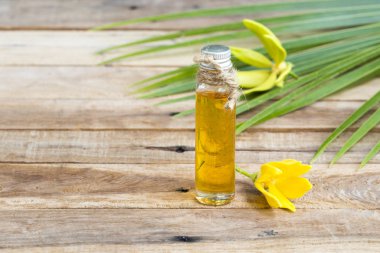Çiçeklerin doğal bitkisel yağları ylang ylang kokusu koku düzenleme düz arka plan ahşap üzerine yatıyordu