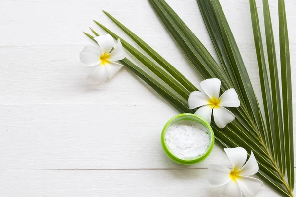 natural herbal coconut scrub health care for surface skin face with coconut leaf ,flowers frangipani arrangement flat lay style on background white