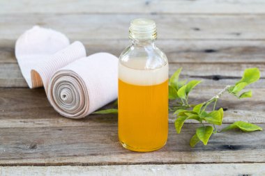 Bitkisel yağ ilaçlarıyla ilk yardım merhem, bandaj sağlık sancıları ve arka plandaki ahşap süsleme için ağrılar.