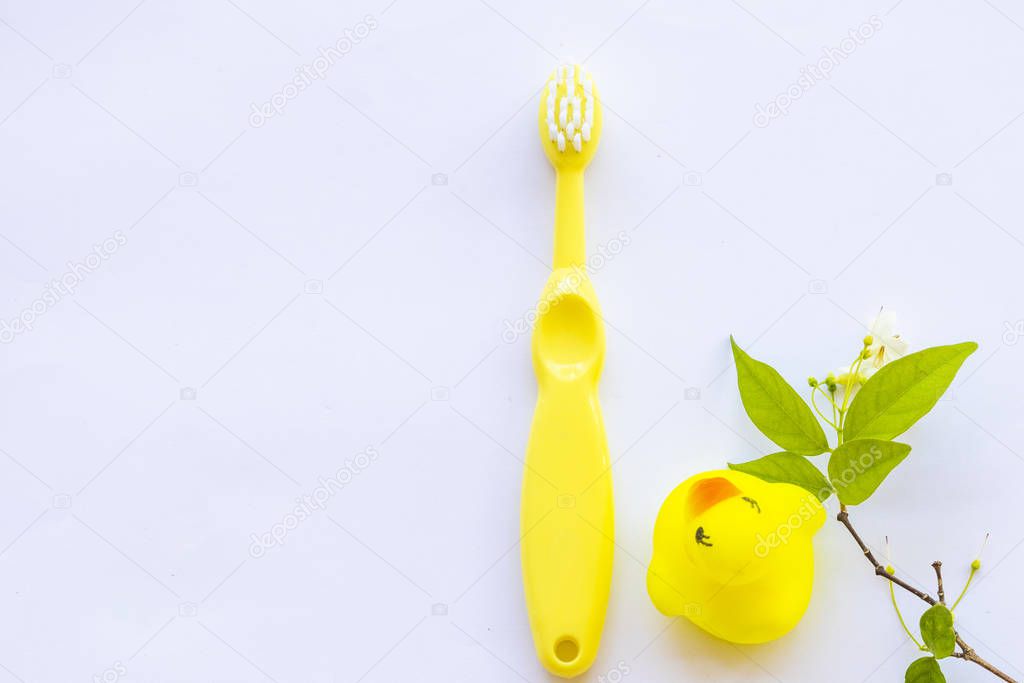  tooth brush of baby 1 years olds with yellow duck toy health care of baby arrangement flat lay style on background white 