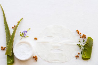 Kolajen maske aromalı doğal bitkisel yatıştırıcı krem cilt düzenleme için aloe vera sağlık maskesi arka plan beyaz ahşap üzerine yatıyordu.