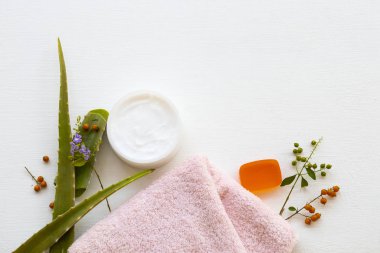 Doğal bitkisel yatıştırıcı krem aroma maskesi cilt bakımı için aloe vera sağlık bakımı bitkisel sabun, yüz havlusu düzenleme düz arka plan beyaz ahşap üzerine yatıyordu